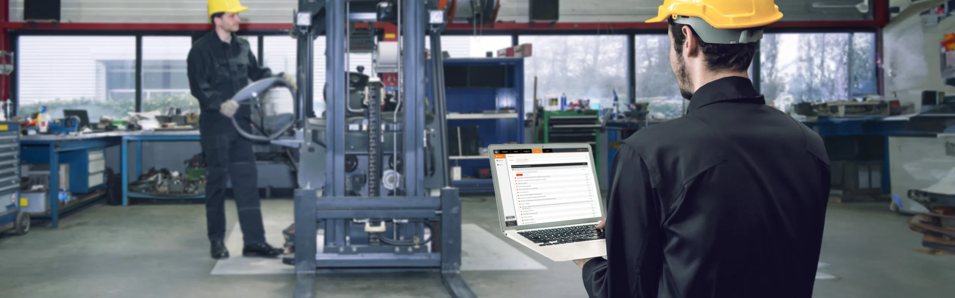 A worker fixing a forklift and another looking at data insights