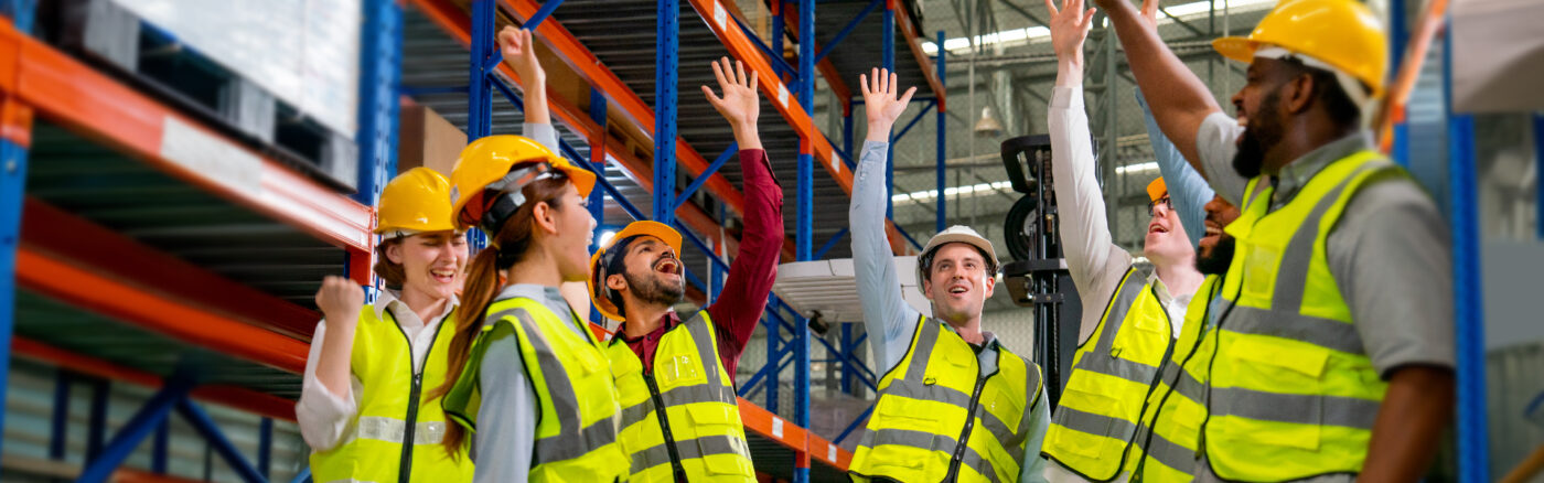warehouse workers in yellow helmets and vests
