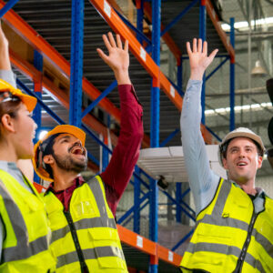 warehouse workers in yellow helmets and vests