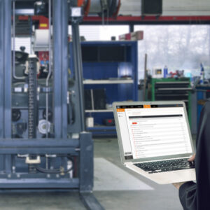 A worker fixing a forklift and another looking at data insights