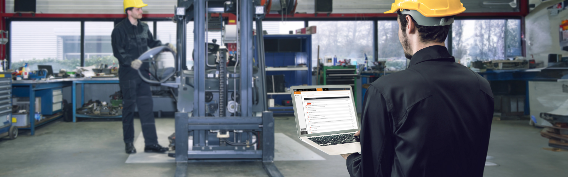 A worker fixing a forklift and another looking at data insights