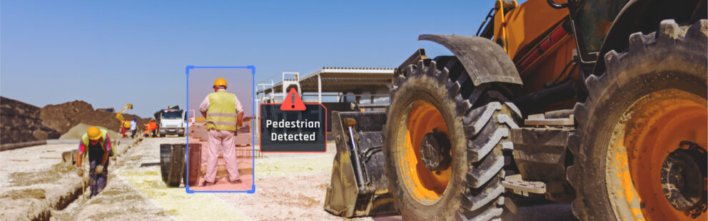 A worker detected by an AI system, highlighted by a blue box and "Pedestrian Detected" warning. Other workers and vehicles are in the background, emphasizing safety in heavy equipment operations.