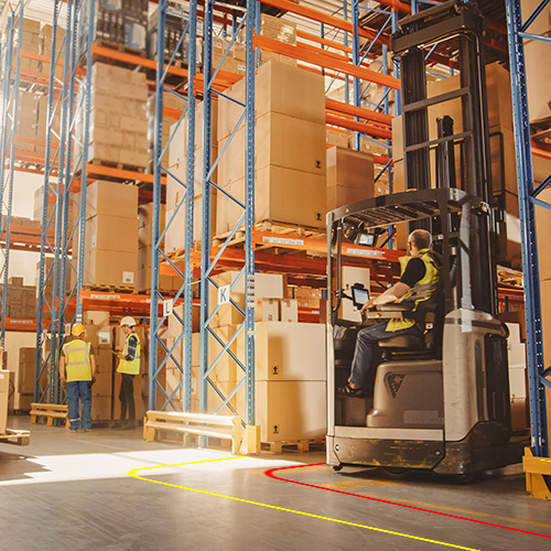 forklift in a paper warehouse near pedestrians